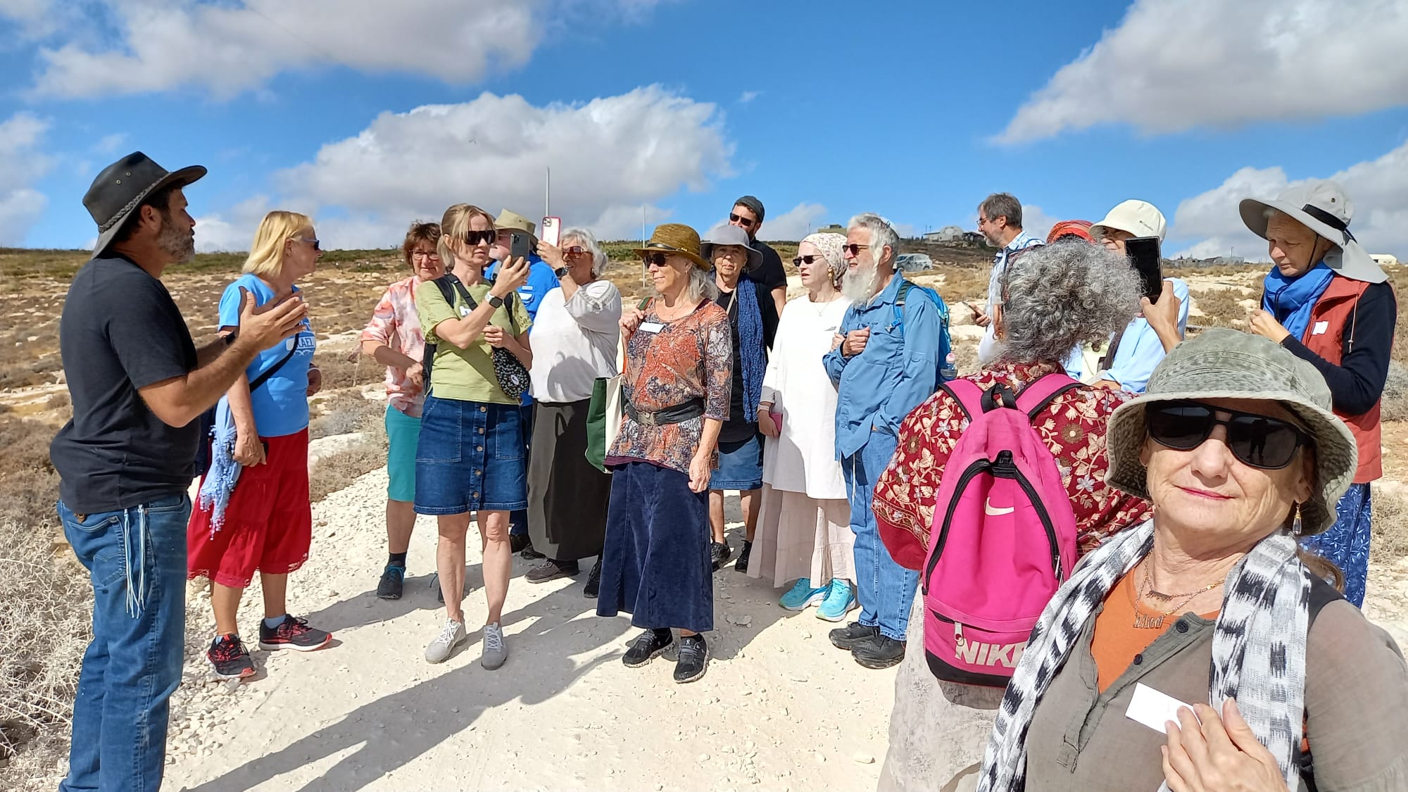 A group learning together outdoors in the hills of Judea